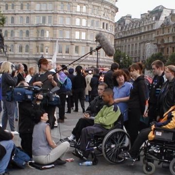 Photo: Young disabled people from GMCDP being interviewed by the media at the march and rally for BSL, Trafalgar Square London, 8 July 2000